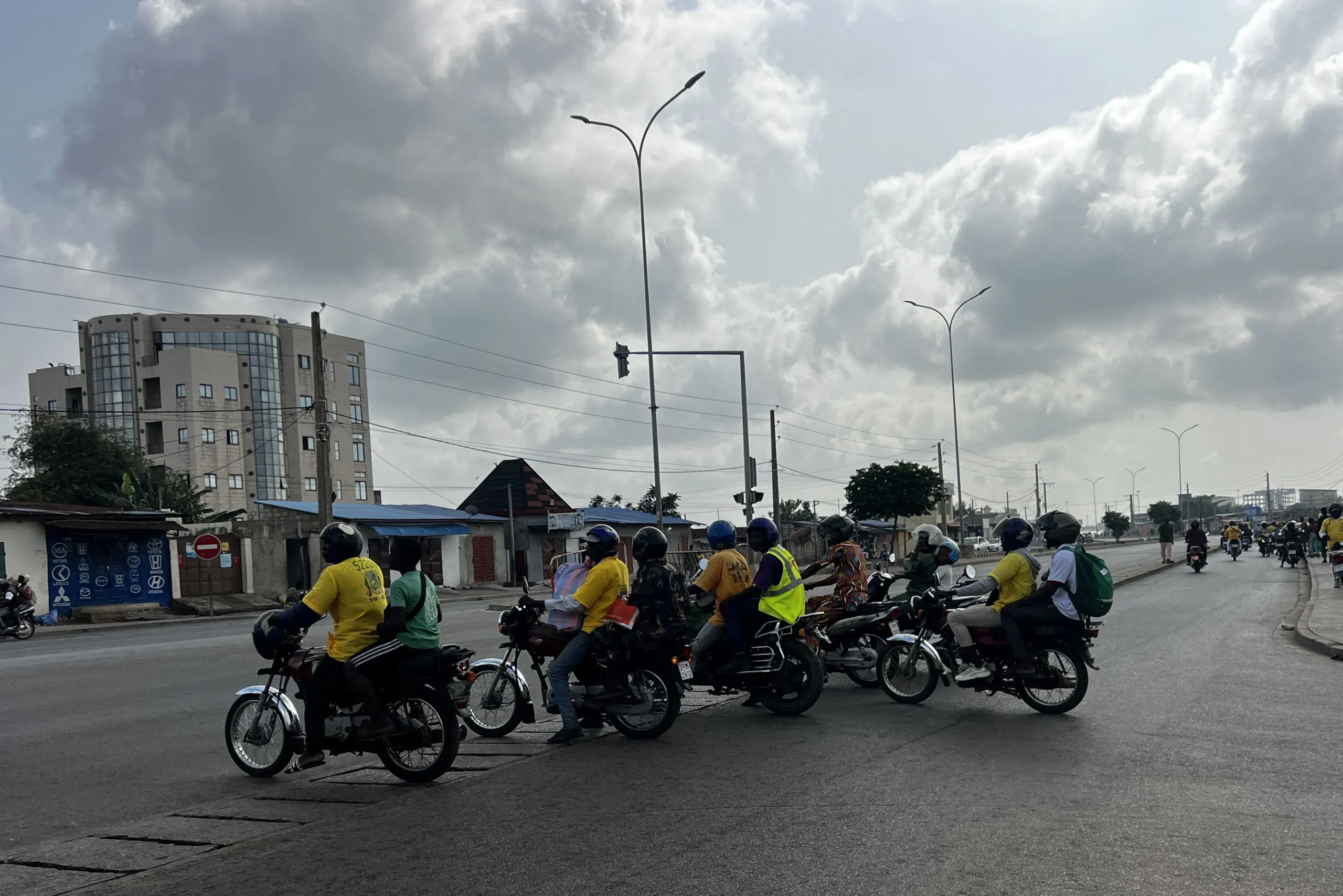 Des motos-taxis transportant des passagers à un carrefour à Cotonou, sur fond de rumeurs d’un possible coup d’État dans le pays, le 7&nbsp;décembre 2025