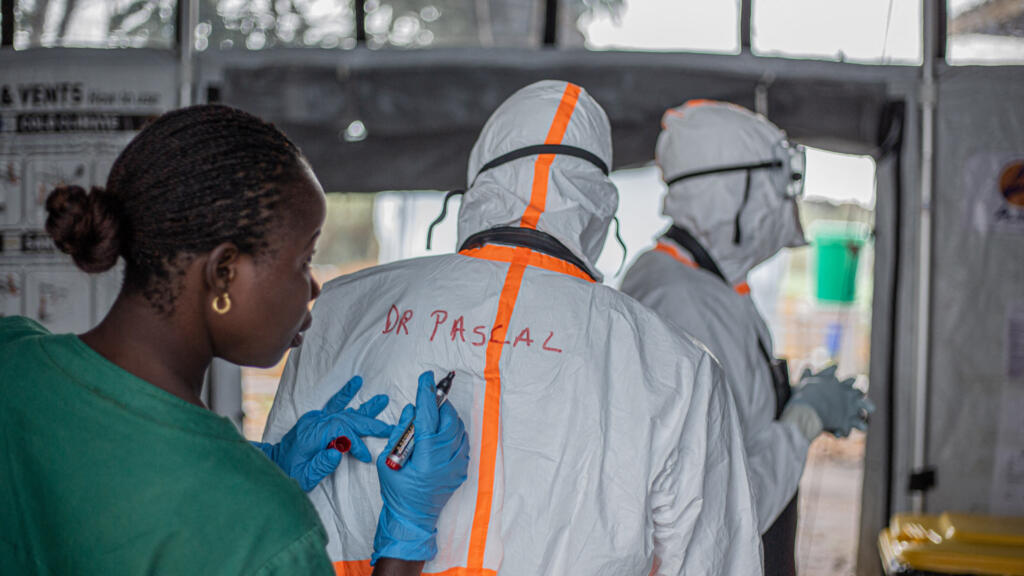 A health worker writes a doctor's name on the back of his personal protective equipment (PPE) before entering the Ebola treatment center (CTE) in Rwampara to treat patients with Ebola virus disease, in Bunia (Ituri), eastern Democratic Republic of Congo, July 13, 2026.