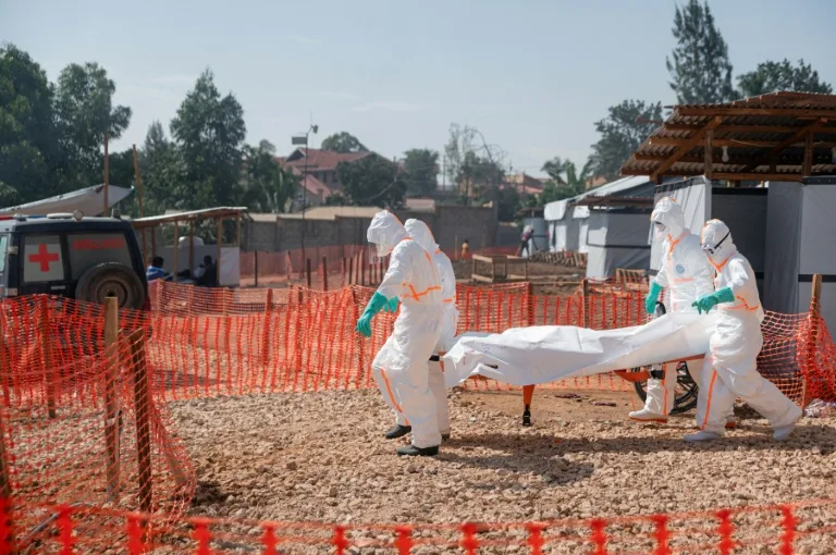 Health workers in protective gear transporting medical supplies