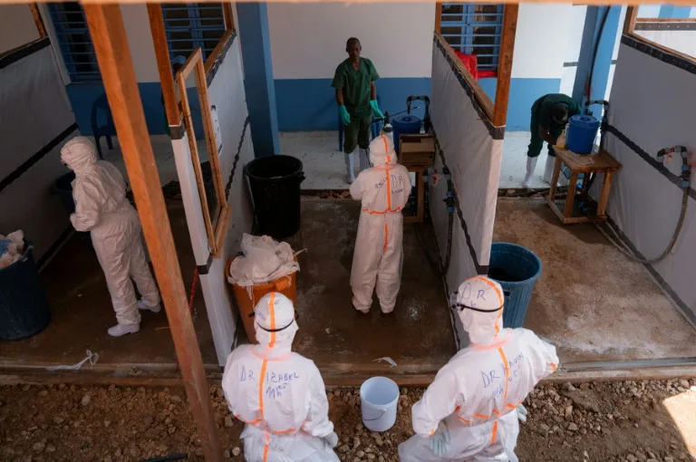 Healthcare workers in protective gear attending to patients during an Ebola outbreak