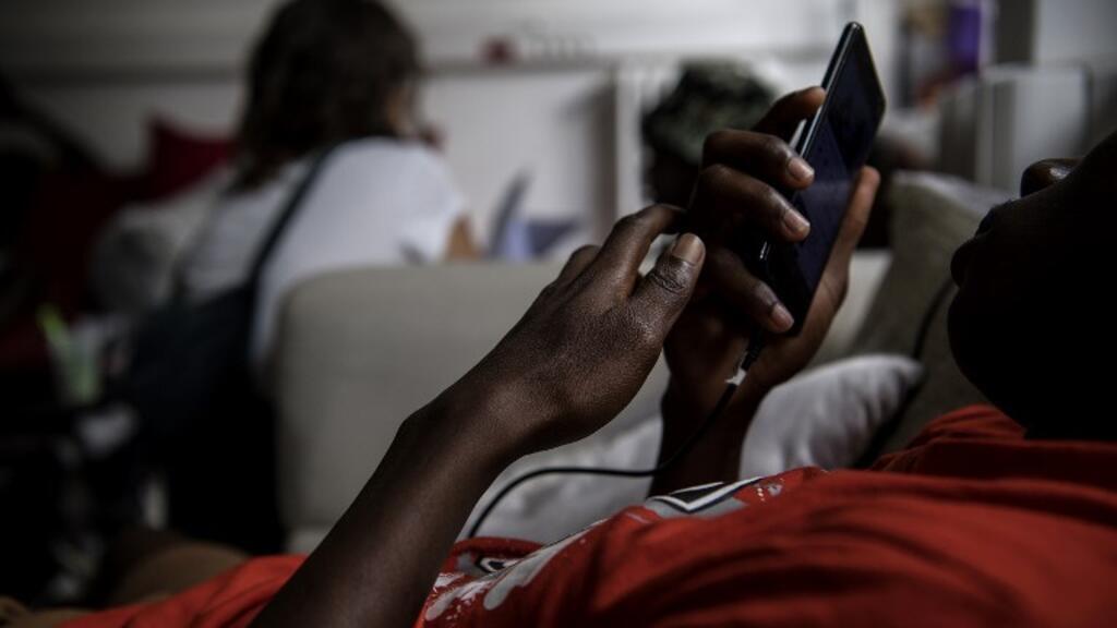 Customers browsing imported phones in Yaoundé market under the new customs system